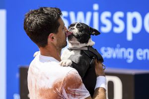 El ganador del Abierto de Suiza 2023, el argentino Pedro Cachin, festeja con besos con su perro Tango. /Foto: Jean-Christophe Bott/Keystone via AP