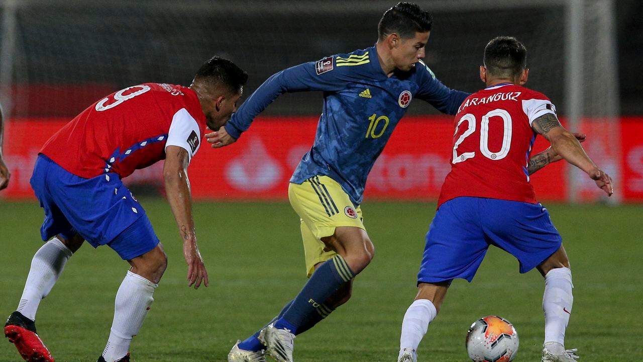 James Rodríguez disputa un balón ante dos rivales chilenos en un partido por eliminatoria disputado en Santiago.