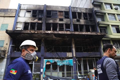 Empleados de emergencia trabajan en el lugar donde un refugio para personas sin hogar se incendió, dejando al menos 10 víctimas, en Porto Alegre, Brasil, el 26 de abril de 2024.