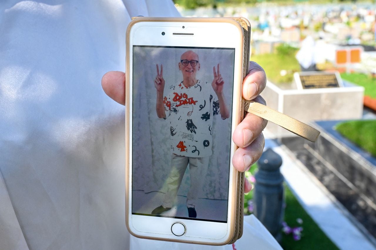 Esta foto tomada el 1 de mayo de 2023 muestra el teléfono de Nazira Lajim Hertslet que muestra una imagen oficial de la "sesión de fotos" de la prisión de su difunto hermano Nazari Lajim, quien fue ejecutado por tráfico de drogas, mientras visita su tumba en un cementerio musulmán en Singapur.