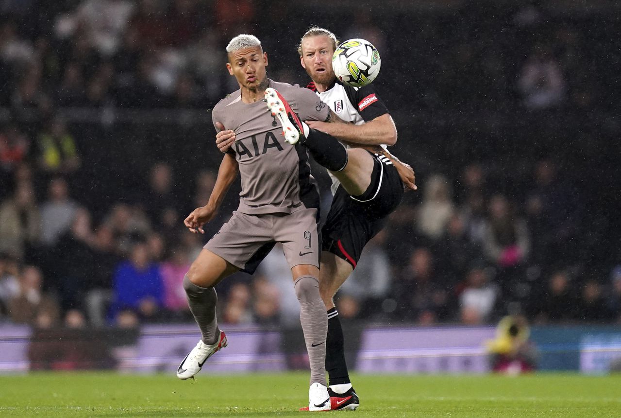 Tim Ream del Fulham intenta quitarle el balón al brasilero Richarlison, del Tottenham, en duelo de la segunda fase de la Copa de la Liga inglesa 2023.