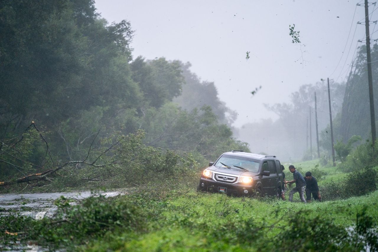MAYO, FLORIDA - AUGUST 30: People work to free a vehicle stuck on the shoulder amid storm debris as Hurricane Idalia crosses the state on August 30, 2023 near Mayo, Florida. The storm made landfall at Keaton Beach, Florida as Category 3 hurricane.   Sean Rayford/Getty Images/AFP (Photo by Sean Rayford / GETTY IMAGES NORTH AMERICA / Getty Images via AFP)