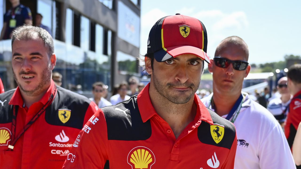El piloto español de Fórmula Uno Carlos Sainz de la Scuderia Ferrari, centro, camina antes de la tercera práctica libre antes del Gran Premio de Hungría de Fórmula Uno del domingo, en el circuito de Hungaroring en Mogyorod, cerca de Budapest, Hungría, el sábado 22 de julio de 2023. (Foto AP/Denes Erdos)