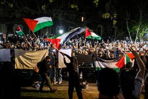 Manifestantes pro palestinos ondean banderas y sostienen teléfonos inteligentes fuera del área vallada de un campamento en el campus de la Universidad de Toronto el 2 de mayo de 2024, en Toronto, Canadá. (Foto de Cole BURSTON / AFP)
