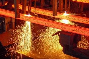 Palanquillas de acero al rojo vivo con chispas en una máquina de colada continua en corte con soplete en un sitio de producción de una planta de acero