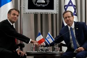 El presidente francés, Emmanuel Macron, a la izquierda, le da la mano al presidente de Israel, Isaac Herzog, en Jerusalén, el martes 24 de octubre de 2023.  (Foto AP/Christophe Ena, Piscina)