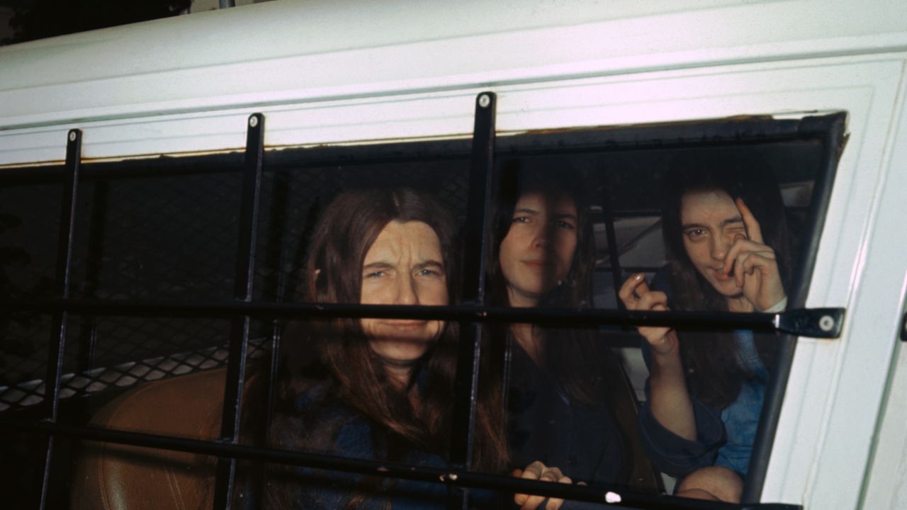 Las tres mujeres de la "familia" de Charles Manson se burlan de los fotógrafos a través de la ventana de la camioneta del alguacil cuando llegan al juzgado para continuar el juicio por asesinato en el caso Tate-LaBianca.
