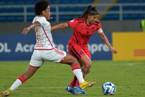 La jugadora del América de Cali, Catalina Usme, intenta disparar al arco de Gabrieri, ante la marca de una jugadora del Internacional, en el partido de la segunda fecha de la Copa Libertadores femenina 2023.