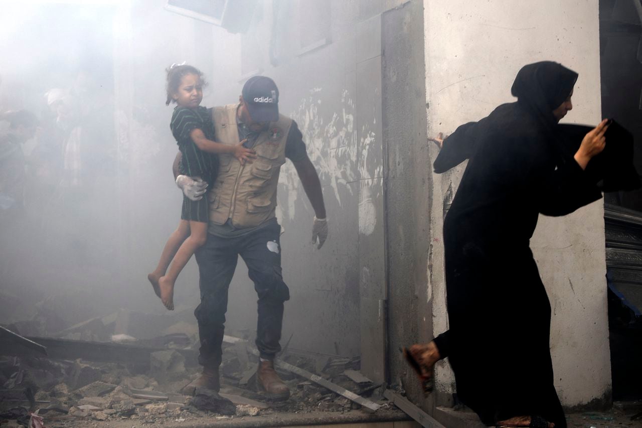 Miembros de una familia palestina salen corriendo de una casa bombardeada durante los ataques aéreos israelíes en la ciudad de Gaza el 9 de octubre de 2023.