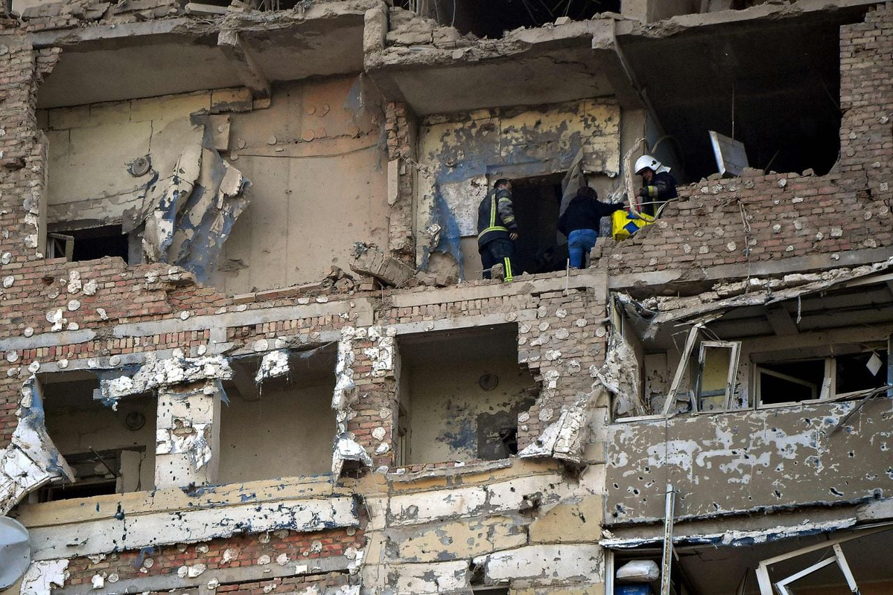 Los rescatistas evacuan a una residente local de un edificio residencial de varios pisos, parcialmente destruido después de los ataques nocturnos con drones en Kiev el 30 de mayo de 2023.