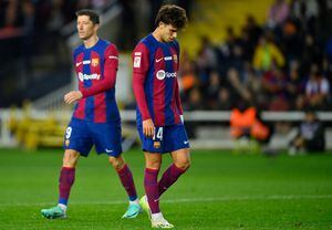 Los jugadores del Barcelona, Joao Felix y Robert Lewandowski, lamentan la derrota del Barsa, de local, frente al Girona en la Liga española este domingo 10 de diciembre de 2023.  /Foto Pau BARRENA / AFP)