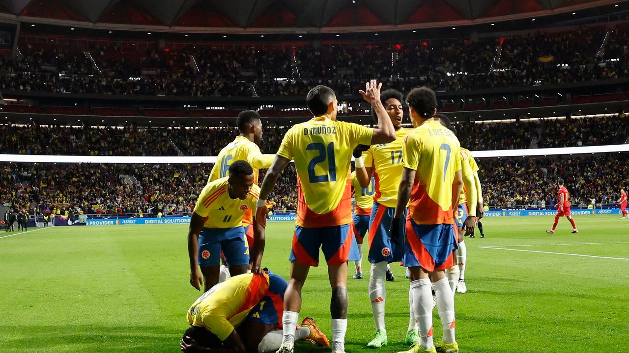 Colombia's forward #09 Jhon Cordoba (down) celebrates with teammates after scoring his team's first goal during the international friendly football match between Romania and Colombia at the Metropolitano stadium in Madrid on March 26, 2024. (Photo by OSCAR DEL POZO / AFP)