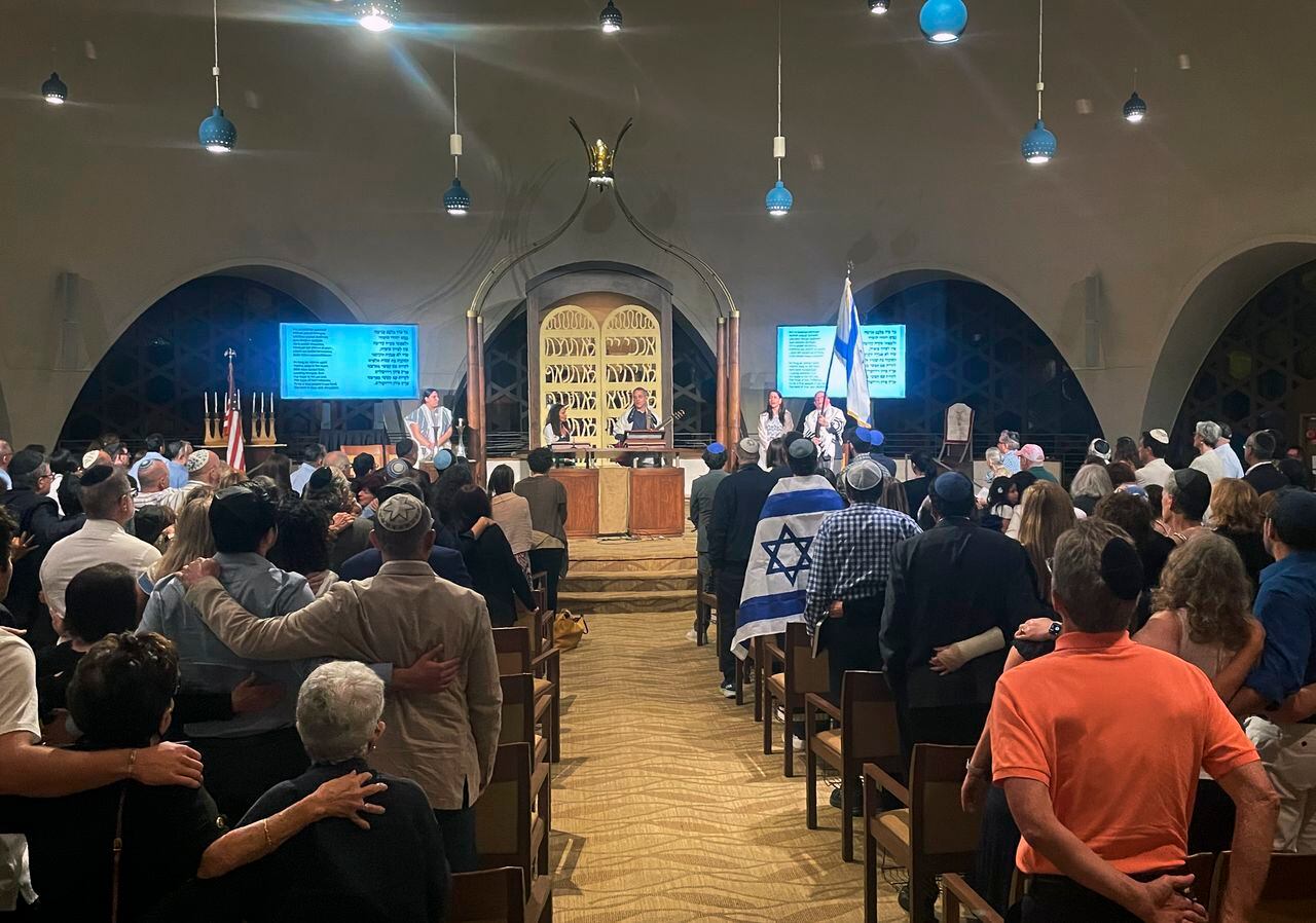 Cerca de 300 personas cantan al final de los servicios del sabbat en un templo de Miami Beach, Florida.