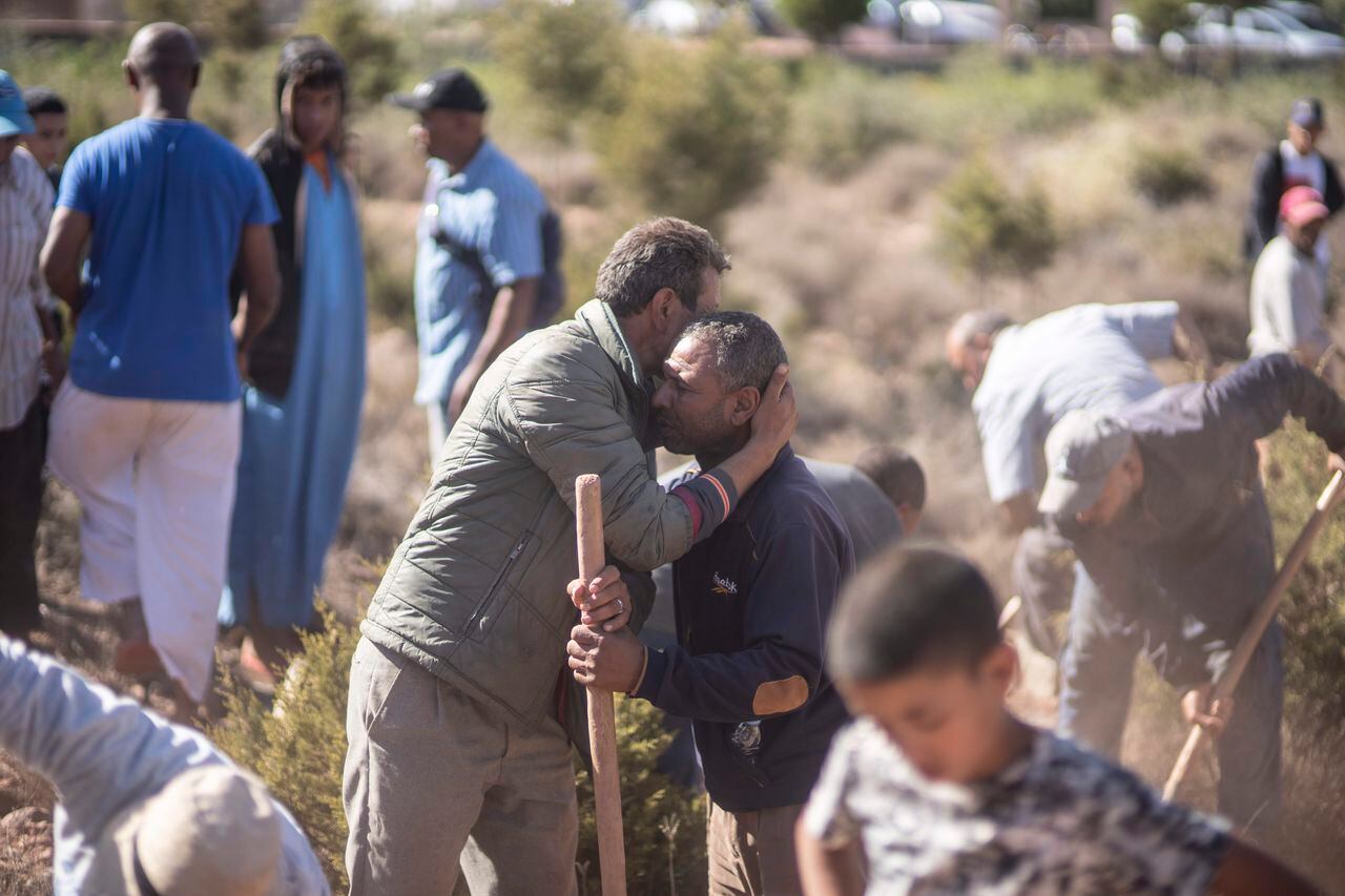 Las personas se consuelan mientras cavan tumbas para las víctimas del terremoto, en la aldea de Ouargane, cerca de Marrakech, Marruecos, el sábado 9 de septiembre de 2023.