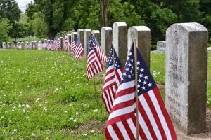 Los marcadores de las tumbas de los veteranos en el cementerio Highland Lawn en Terre Haute, Indiana, están decorados con pequeñas banderas estadounidenses el lunes 25 de mayo de 2020 para el Día de los Caídos. (Austen Leake / The Tribune-Star a través de AP)
