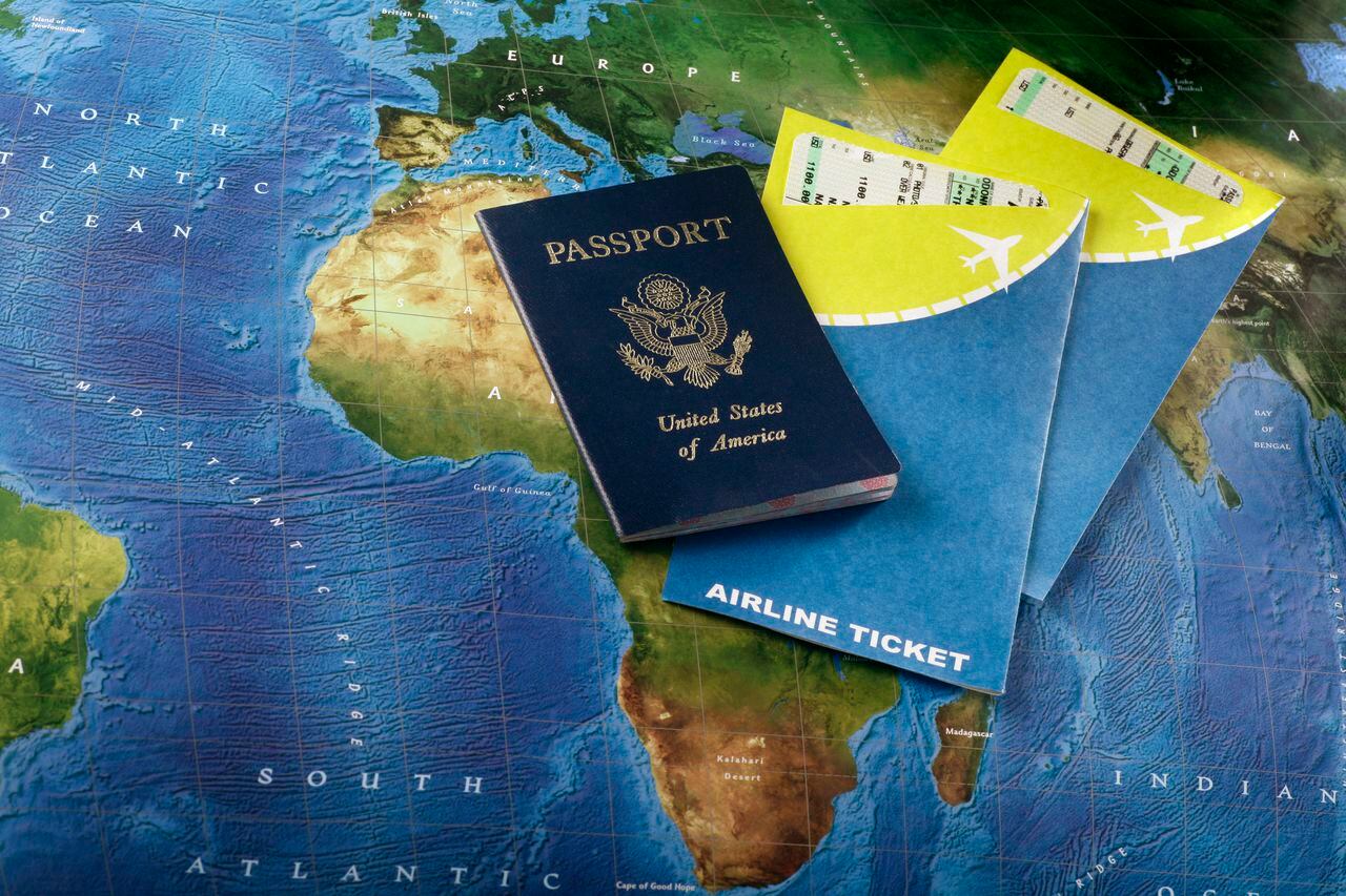 Foto de referencia sobre pasaportes y tiquetes aéreos a África, cuyo mapa sale debajo de los documentos