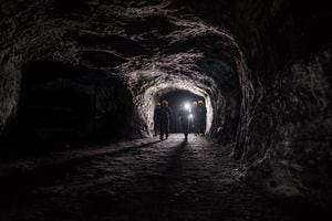 Grupo de hombres en una mina subterránea oscura - conceptos de minería