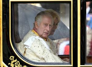 El rey Carlos III y la reina Camila son transportados en el carruaje estatal del Jubileo de Diamante cuando la Procesión del Rey llega a la Abadía de Westminster para su ceremonia de coronación en Londres, el sábado 6 de mayo de 2023.(Toby Melville, Pool via AP)
