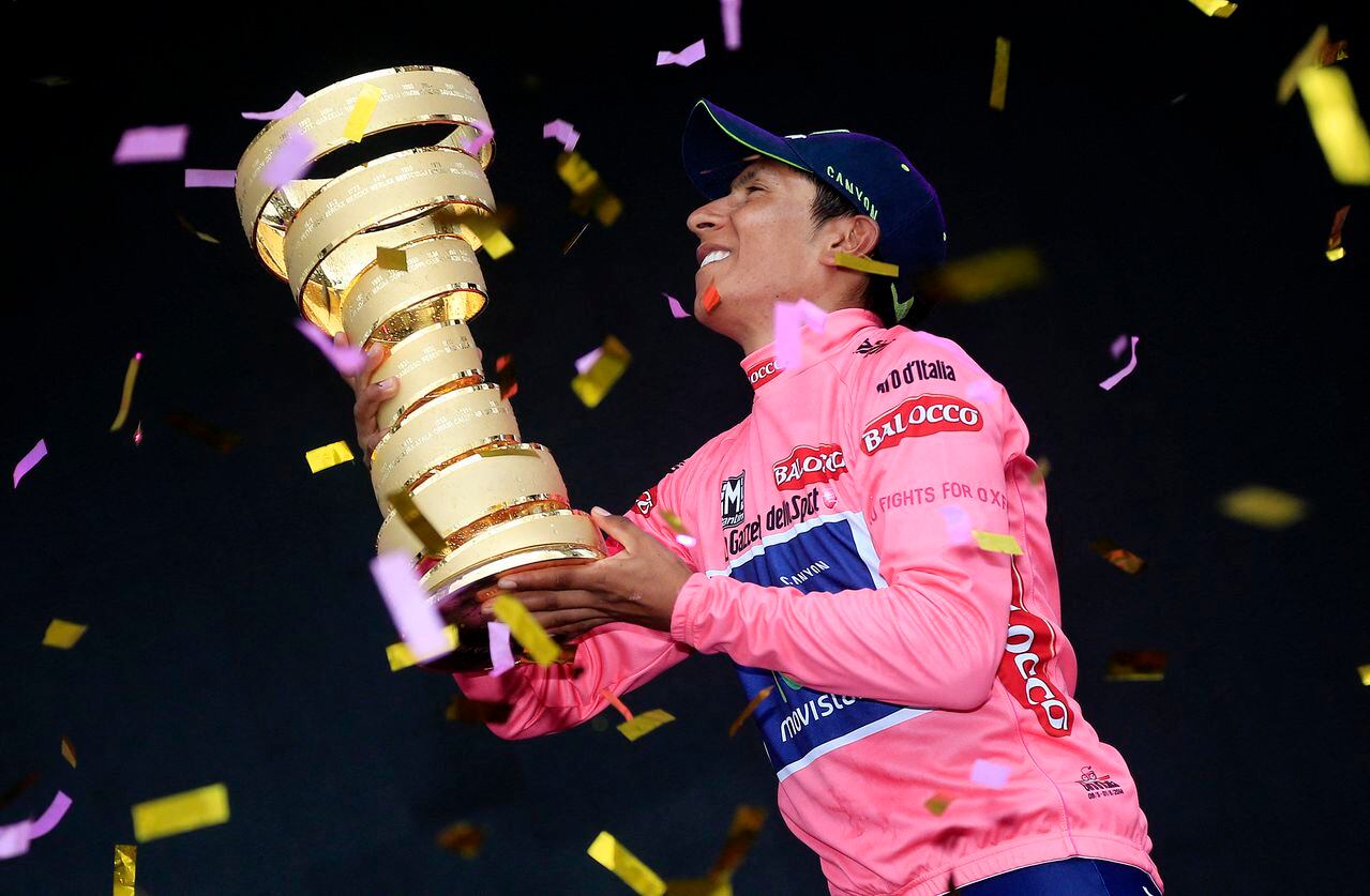El colombiano Nairo Quintana sostiene el trofeo mientras celebra en el podio con el líder del maillot rosa de la clasificación general, tras ganar la 97ª carrera ciclista del Giro de Italia, al final de la 21ª y última etapa, de 172 kilómetros. de Gemona a Trieste, el 1 de junio de 2014 en Trieste. AFP PHOTO/LUK BENIES (Foto de LUK BENIES / AFP)