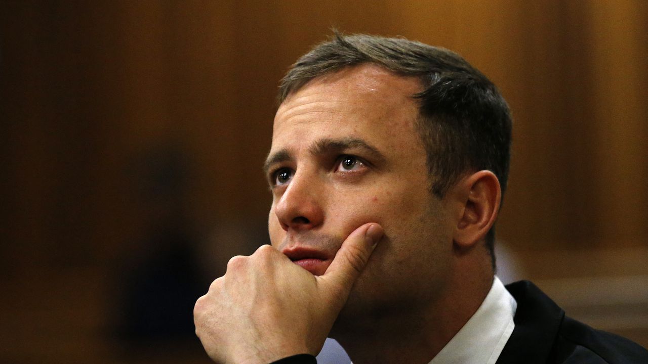 (FILES) South African paralympic athlete Oscar Pistorius waits on October 16, 2014 before his sentencing hearing at the North Gauteng High Court in Pretoria. South African Paralympic champion Oscar Pistorius was granted early release from prison on parole on Friday, a decade after he killed his girlfriend, in a crime that gripped the world, prison authorities said. (Photo by SIPHIWE SIBEKO / POOL / AFP)