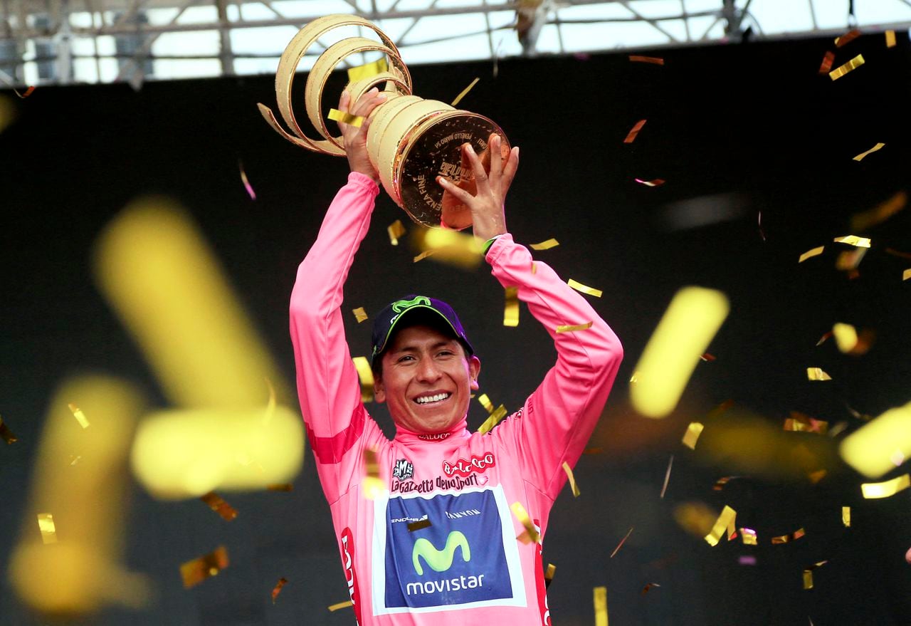 El colombiano Nairo Quintana celebra en el podio con el trofeo y el maillot rosa de líder de la clasificación general, tras ganar la 97ª carrera ciclista del Giro de Italia, al final de la 21ª y última etapa, a 172 kilómetros de Gemona. a Trieste, el 1 de junio de 2014 en Trieste. AFP PHOTO/LUK BENIES (Foto de LUK BENIES / AFP)
