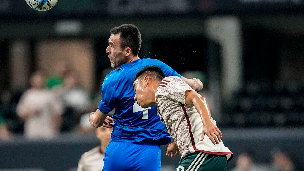 El defensor de Uzbekistán Farrux Sayfiev (4) cabecea el balón junto al mediocampista mexicano Carlos Rodríguez (8) durante la primera mitad de un partido amistoso internacional de fútbol el martes 12 de septiembre de 2023 en Atlanta. (Foto AP/Mike Stewart)