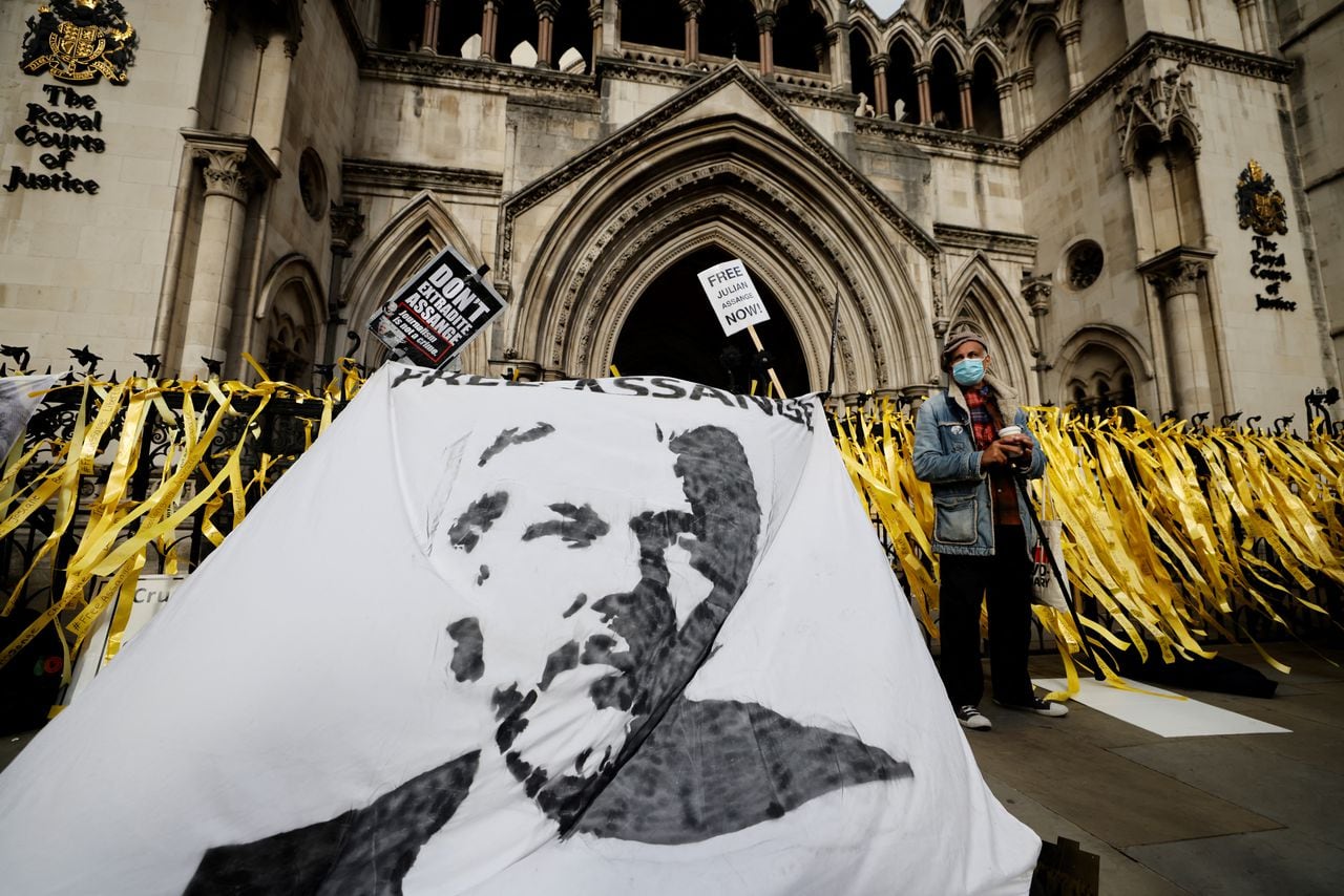 Los manifestantes muestran una pancarta con una imagen del fundador de WikiLeaks, Julian Assange, durante una manifestación frente a los Tribunales Reales de Justicia en Londres el 28 de octubre de 2021, el segundo día de una audiencia de apelación del gobierno de Estados Unidos contra la negativa del Reino Unido a extraditar a Assange. - Estados Unidos instó a dos jueces británicos de alto rango a que autoricen la extradición del fundador de WikiLeaks, Julian Assange, y rechacen la decisión de un tribunal inferior de que existe riesgo de suicidio. (Foto de Tolga Akmen / AFP)