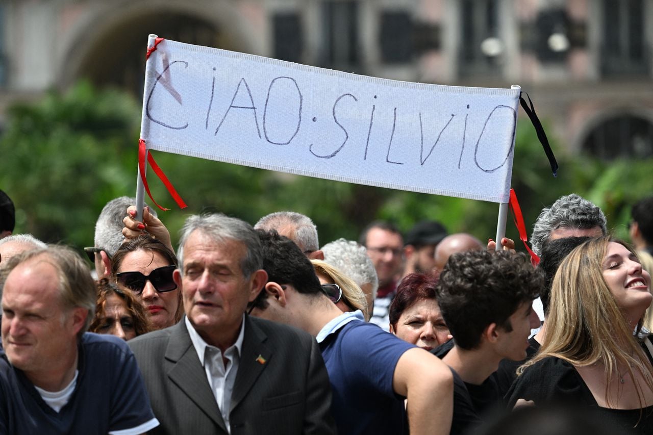 La gente sostiene una pancarta que dice "Adiós Silvio".