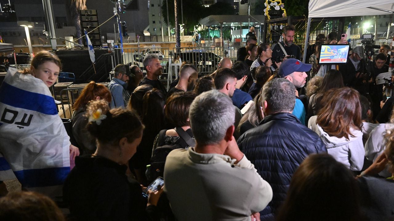 La gente ve las transmisiones de noticias mientras los rehenes son liberados en Egipto antes de ser llevados a Israel por el CICR, afuera del Museo de Tel Aviv el 24 de noviembre de 2023 en Tel Aviv, Israel.