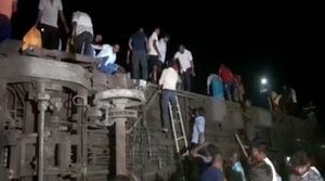 Las personas intentan escapar de los compartimentos volcados, luego de la colisión mortal de dos trenes, en Balasore, India, el 2 de junio de 2023