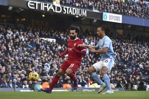 Liverpool's Mohamed Salah, left, challenges for the ball with Manchester City's Nathan Ake during the English Premier League soccer match between Manchester City and Liverpool at Etihad stadium in Manchester, England, Saturday, Nov. 25, 2023. (AP Photo/Rui Vieira)