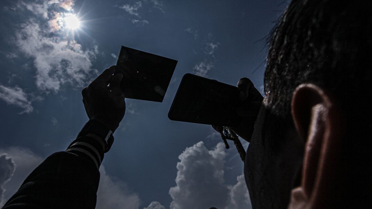 Un hombre usa un espejo protector para observar el eclipse solar en Palembang, Indonesia, el 20 de abril de 2023. El eclipse solar híbrido es un tipo único de eclipse solar que experimenta dos fases simultáneamente, a saber, la fase de anillo y la fase total.