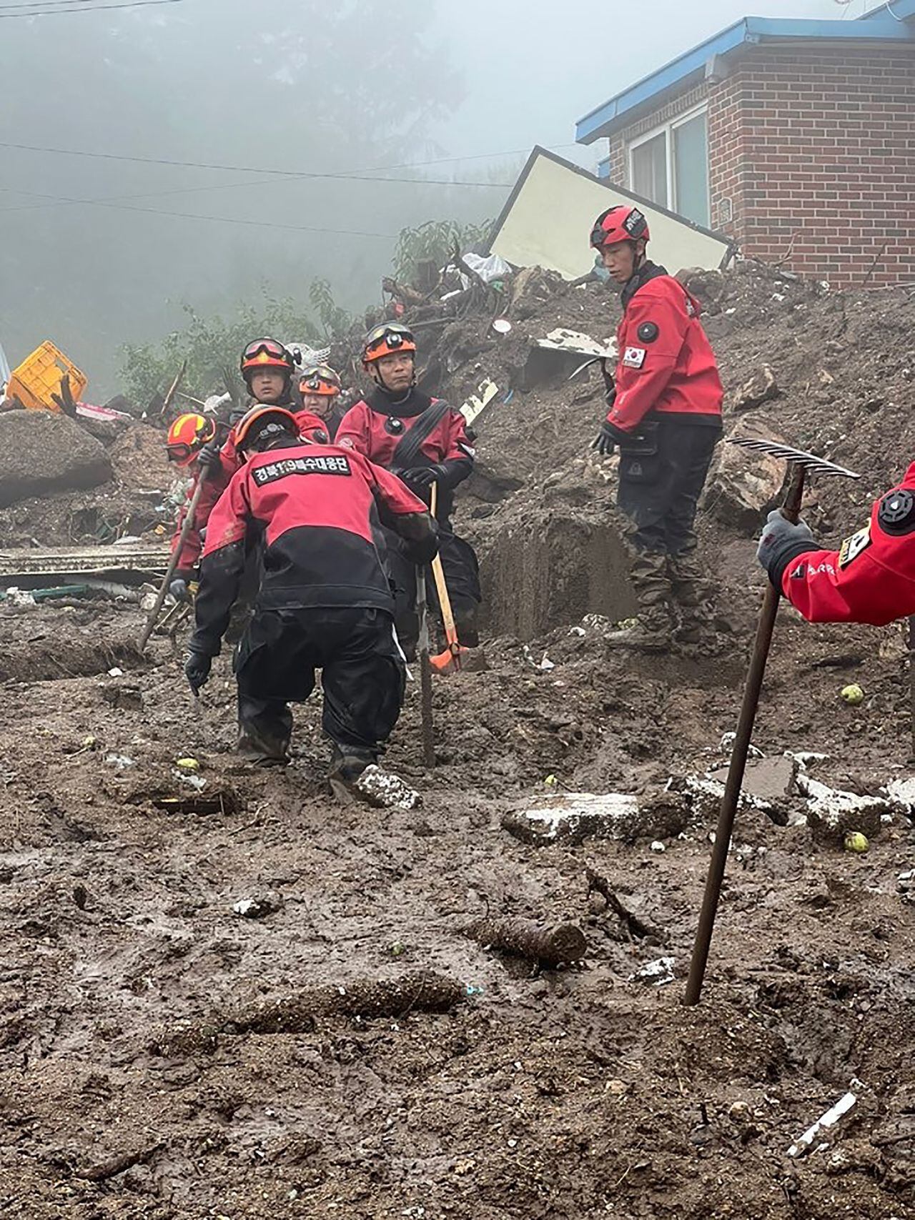 Trabajadores de rescate de Corea del Sur buscan personas desaparecidas después de que un deslizamiento de tierra azotara un pequeño pueblo luego de fuertes lluvias en Yecheon.