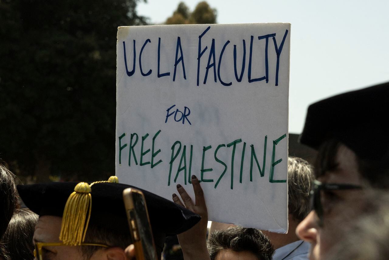 Un manifestante sostiene un cartel que dice "Facultad de UCLA por una Palestina libre.