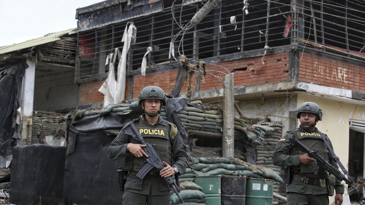 Police stand guard before a damaged police station after a car bomb exploded, in Timba, Cauca, Colombia, Sunday, Aug. 13, 2023. According to police, the car bomb killed one police officer. (AP Photo/Andres Quintero)