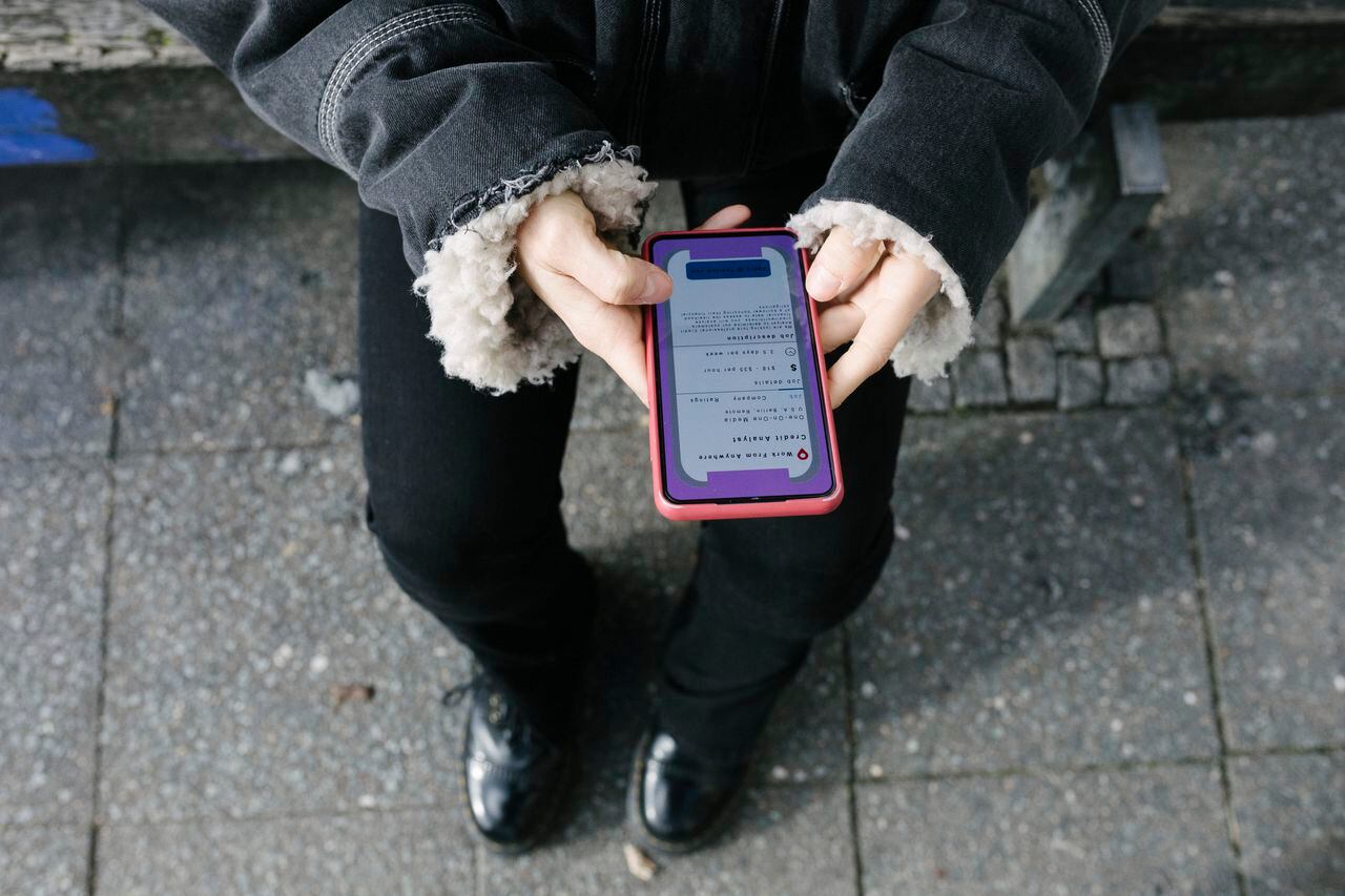 A high angle view of a woman messaging on her smartphone while standing in the street.