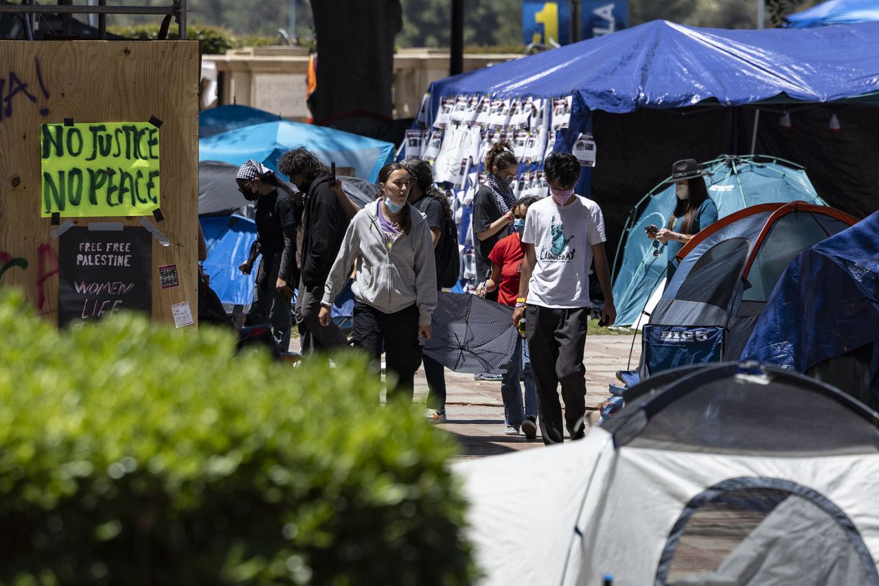 La gente camina dentro de un campamento de protesta pro palestino en el campus de la Universidad de California.