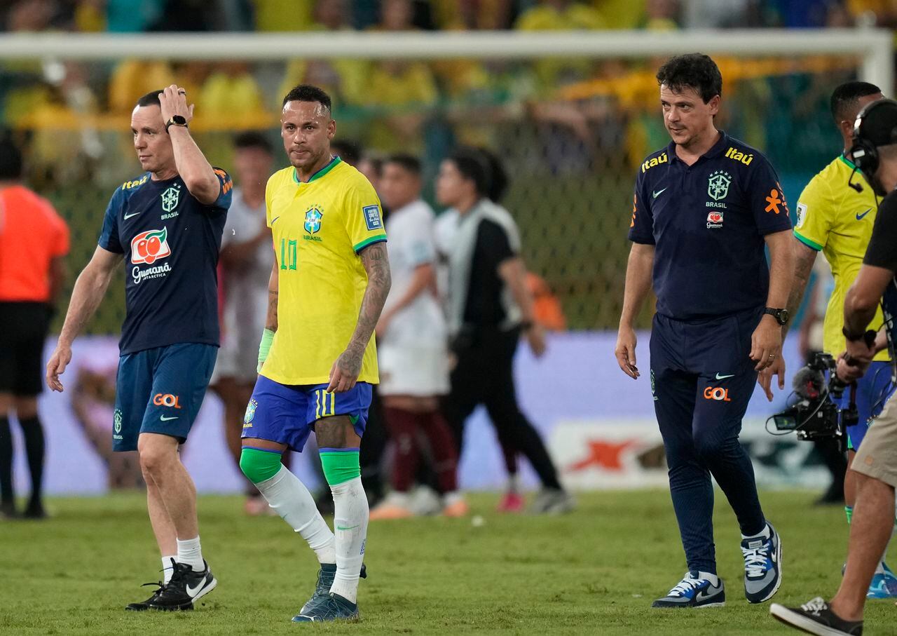 Brazil's coach Fernando Diniz, right, and Brazil's Neymar leave the pitch at the end of a qualifying soccer match for the FIFA World Cup 2026 against Venezuela at Arena Pantanal stadium in Cuiaba, Brazil, Thursday, Oct.12, 2023. The game ended in a 1-1 tie. (AP Photo/Andre Penner)