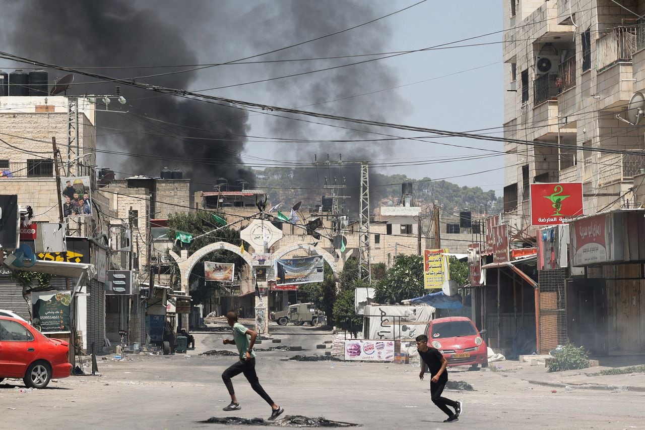 Jóvenes palestinos buscan refugio en medio de enfrentamientos durante una operación militar israelí en la ciudad de Jenin, en la Cisjordania ocupada, el 3 de julio de 2023.