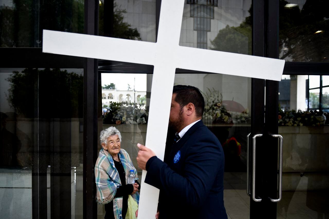 A woman outside the chapel "Capelinha das Aparicoes" looks at a man carrying a cross at Fatima, central Portugal, on May 11, 2017. Two of the three child shepherds who reported apparitions of the Virgin Mary in Fatima, Portugal, one century ago, will be declared saints on May 13, 2017 by Pope Francis.
The canonisation of Jacinta and Francisco Marto will take place during the Argentinian pontiff's visit to a Catholic shrine visited by millions of pilgrims every year. (Photo by PATRICIA DE MELO MOREIRA / AFP)