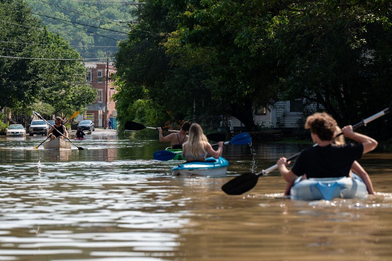 La gente sube y baja en kayak por las aguas inundadas de Elm Street el 11 de julio de 2023 en Montpelier, Vermont.