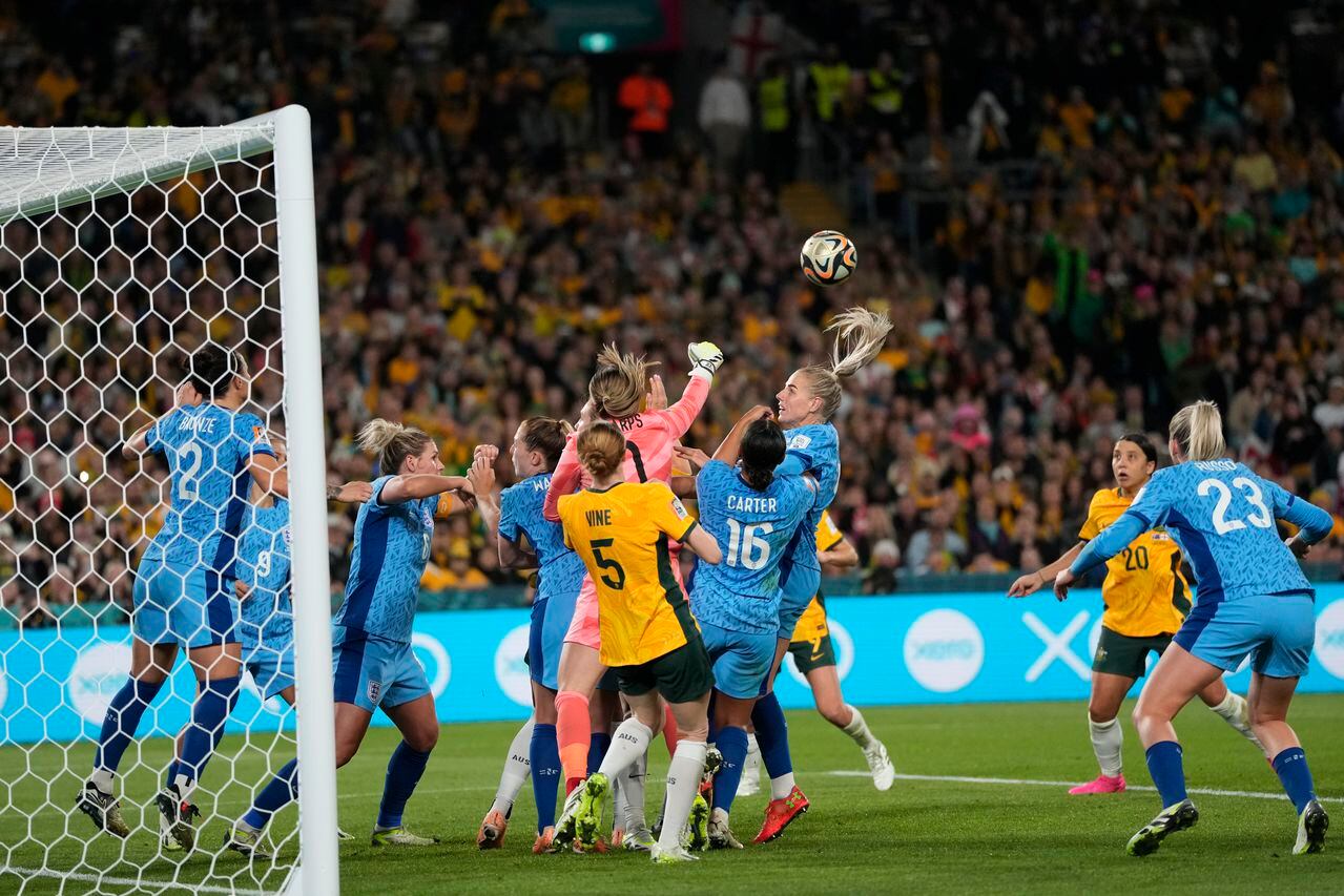 La arquera de Inglaterra, Mary Earps, en el centro, golpea el balón para evitarlo durante el partido de fútbol de la semifinal de la Copa Mundial Femenina entre Australia e Inglaterra en el Estadio Australia en Sídney, Australia, el miércoles 16 de agosto de 2023. (Foto AP/Rick Rycroft)