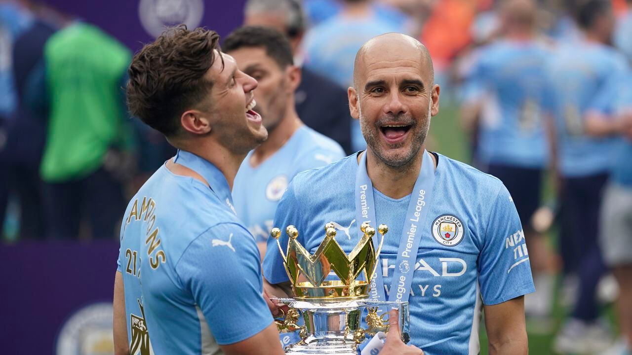 FILE - Manchester City's head coach Pep Guardiola, right, smiles with trophy after winning the 2022 English Premier League title at the Etihad Stadium in Manchester, England, on May 22, 2022. (AP Photo/Dave Thompson, File)