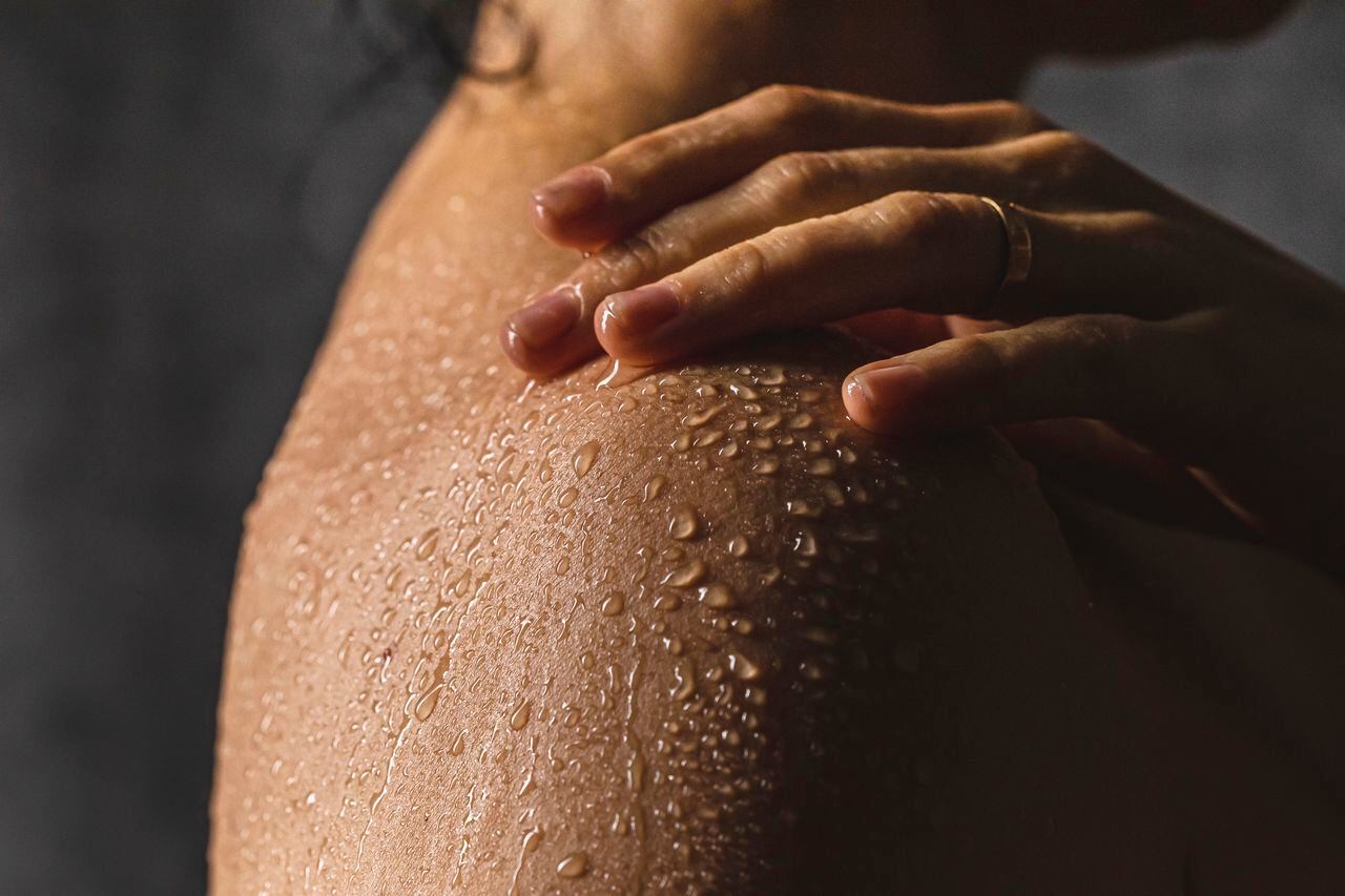 Foto de referencia de gotas de agua sobre la piel de una mujer