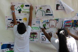 Dos niños pegan sus dibujos alusivos a la novela 'María' durante la Feria Internacional del Libro de Cali. (Foto: Bernardo Peña)