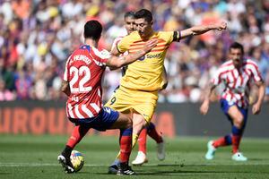 El delantero polaco de Barcelona, ​​Robert Lewandowski (D), compite con el defensa español del Atlético de Madrid, Mario Hermoso, durante un partido de la Liga española.