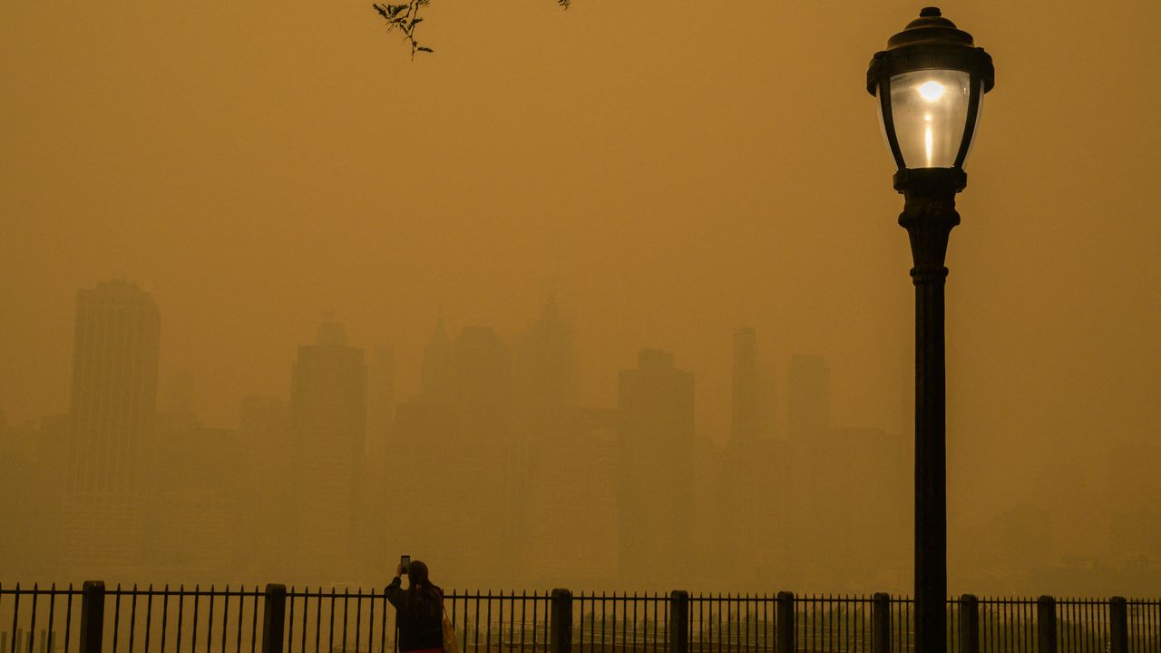 Una persona toma fotos del horizonte mientras el humo de los incendios forestales en Canadá causa condiciones de niebla en la ciudad de Nueva York el 7 de junio.