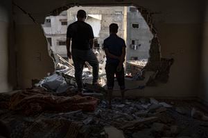 Los palestinos observan la destrucción tras los ataques israelíes en la Franja de Gaza en Khan Younis, el sábado ahora. 4 de diciembre de 2023. (Foto AP/Fatima Shbair)