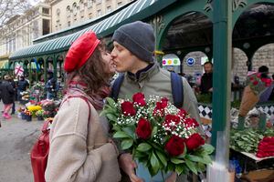 Una pareja comparte un tierno momento cerca de un mercado de flores que celebra el Día Internacional de la Mujer en Tiflis, Georgia, el martes 8 de marzo de 2022. (AP Photo/Shakh Aivazov)