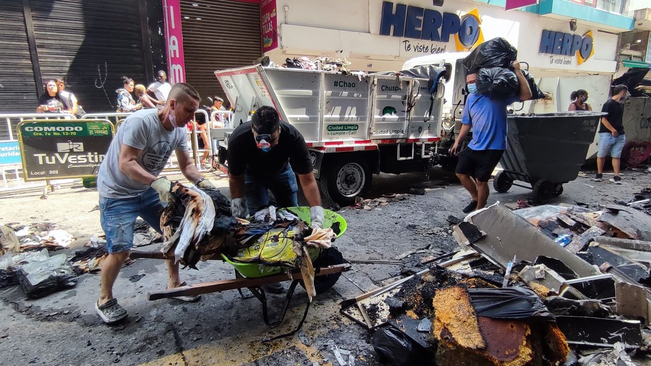 Comerciantes del centro de Cali rescatan lo que pueden del centro comercial el tesoro luego del incendio que consumió a este establecimiento.